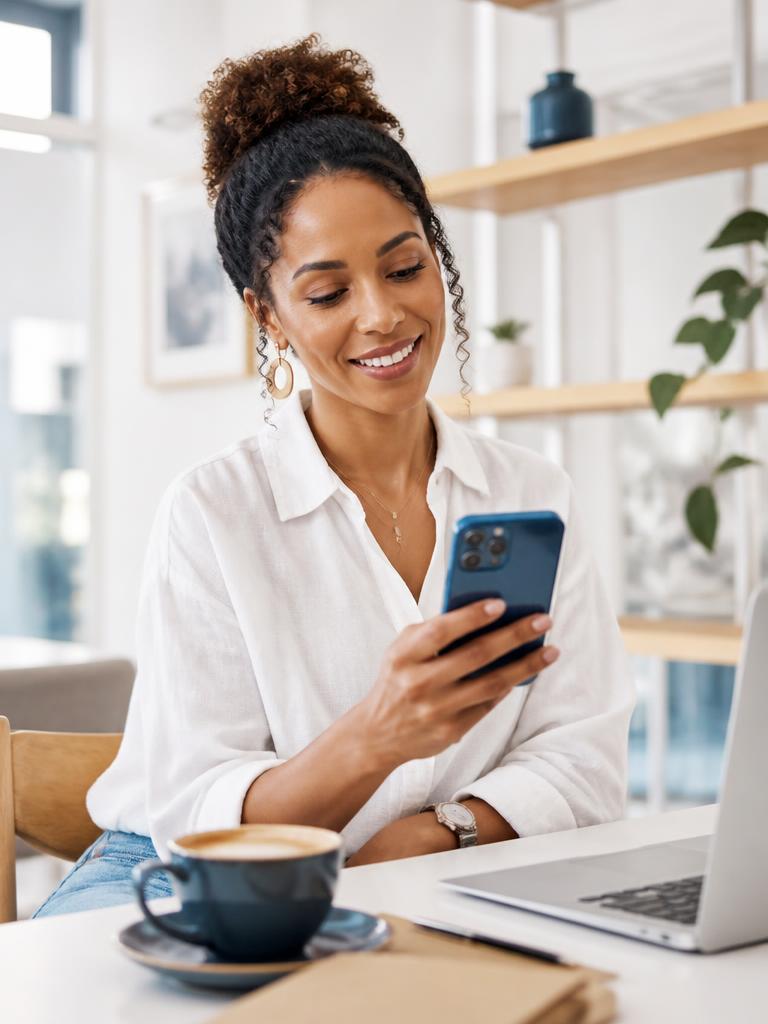 A South African woman reviewing her expenses on the eScripts mobile app in a café